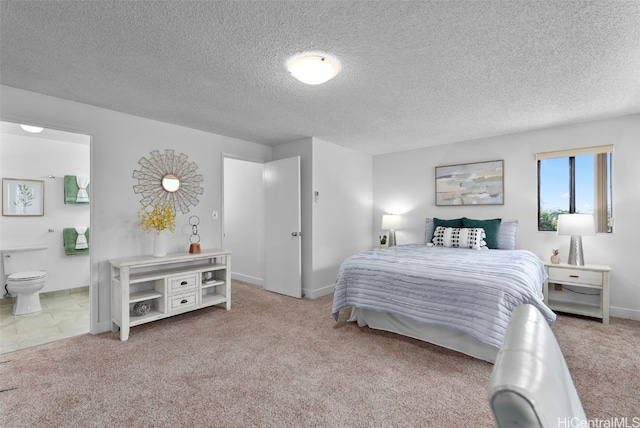 bedroom with connected bathroom, light carpet, and a textured ceiling