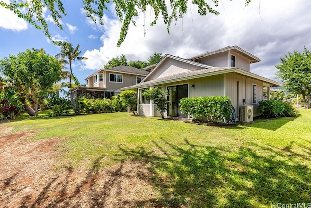 rear view of house with a lawn and ac unit