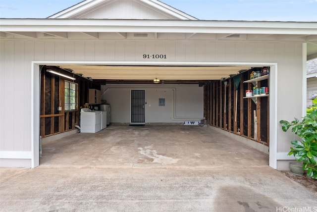 garage featuring water heater and washing machine and clothes dryer