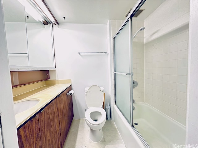 full bathroom with toilet, bath / shower combo with glass door, vanity, and tile patterned flooring