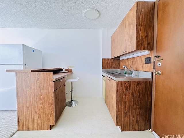 kitchen featuring kitchen peninsula, a textured ceiling, and sink