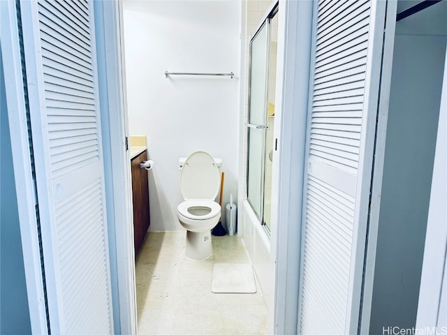 full bathroom featuring vanity, bath / shower combo with glass door, and toilet