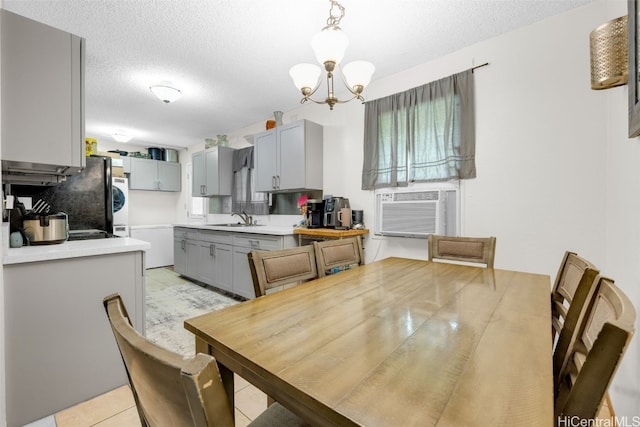 tiled dining area featuring sink, cooling unit, a notable chandelier, and a textured ceiling