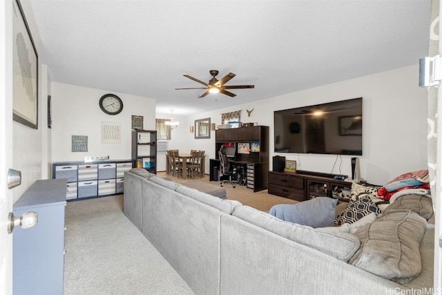 living room featuring carpet floors and ceiling fan with notable chandelier