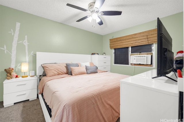 bedroom featuring cooling unit, a textured ceiling, dark carpet, and ceiling fan