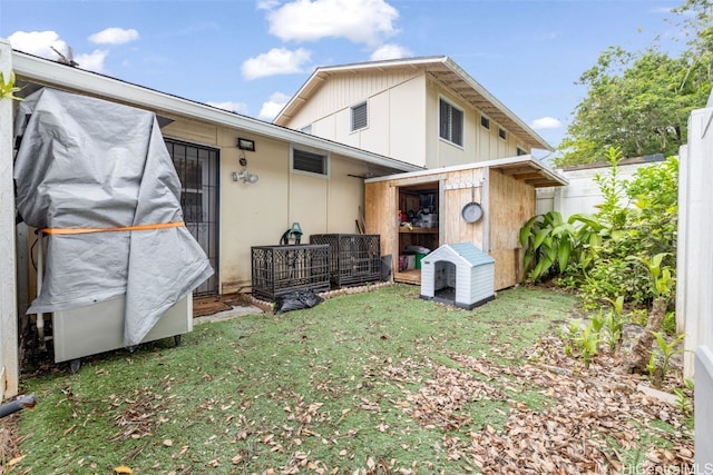 back of house featuring a storage shed and a yard