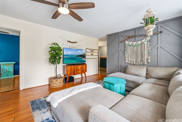 bedroom with ceiling fan, a textured ceiling, and hardwood / wood-style floors