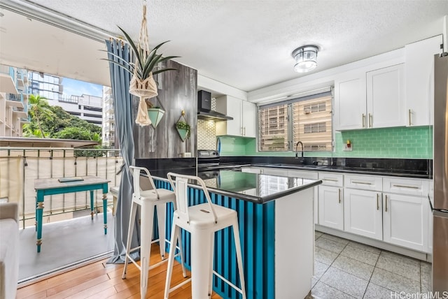 kitchen featuring white cabinetry, backsplash, and sink