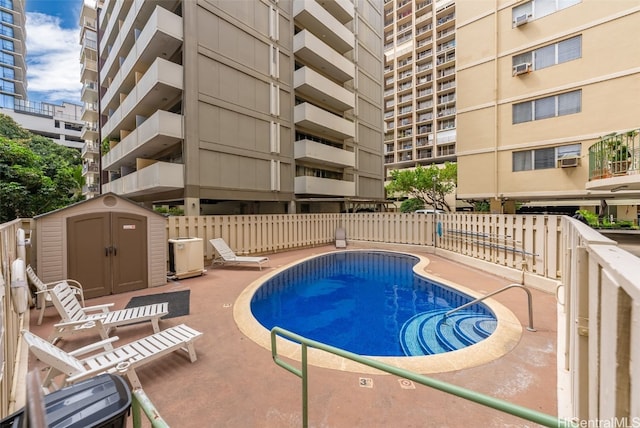 view of pool featuring a patio area and a storage unit