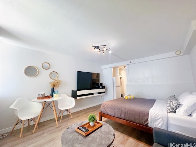 bedroom featuring white fridge and wood-type flooring