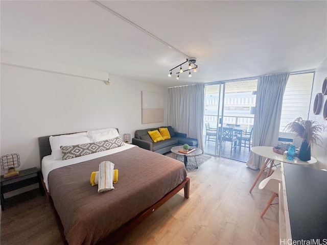 bedroom with light hardwood / wood-style flooring, access to exterior, and floor to ceiling windows