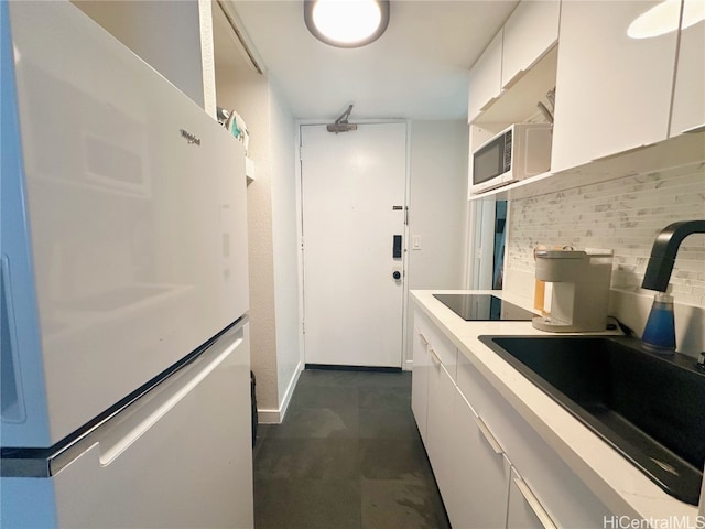 kitchen featuring white appliances, white cabinetry, sink, and decorative backsplash