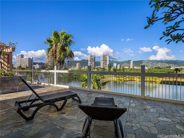 surrounding community with a water view and a patio