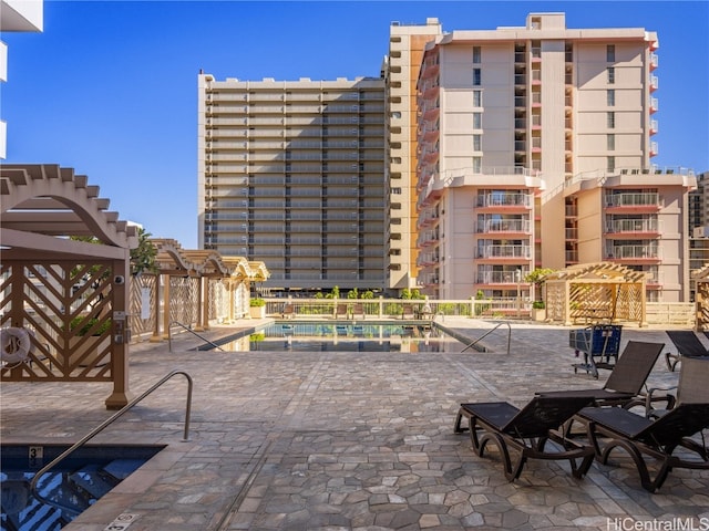 view of patio with a community pool and a pergola