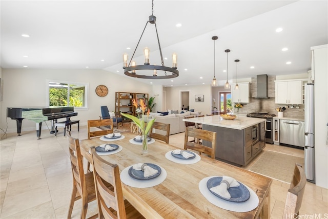 dining room with lofted ceiling, an inviting chandelier, and light tile patterned floors