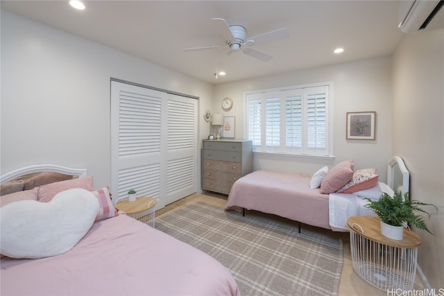 bedroom with a closet, an AC wall unit, and ceiling fan