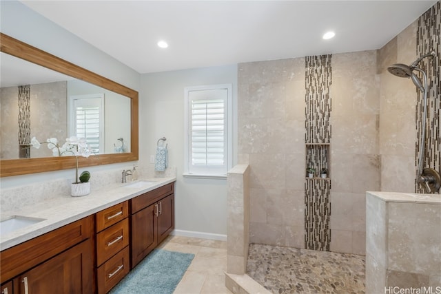 bathroom with vanity, tiled shower, and tile patterned flooring