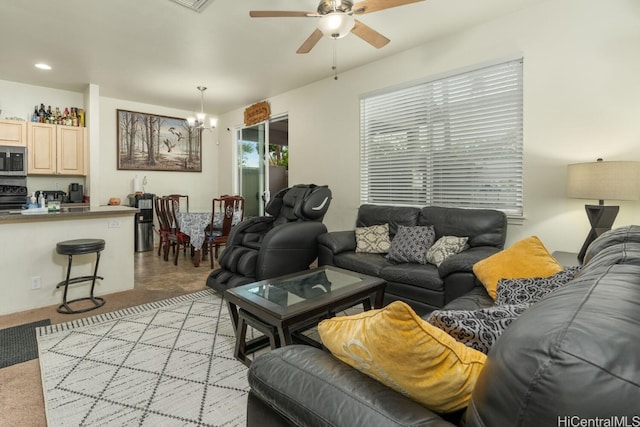 carpeted living room featuring ceiling fan with notable chandelier