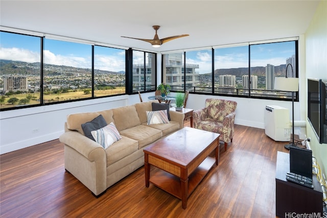 living room with a wealth of natural light, ceiling fan, and dark hardwood / wood-style flooring