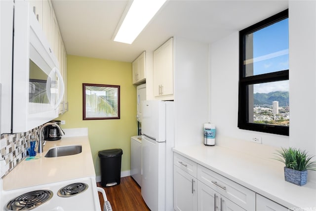 kitchen featuring dark wood-style flooring, tasteful backsplash, a sink, stacked washer and clothes dryer, and white appliances