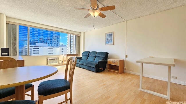 dining space featuring light hardwood / wood-style floors, a textured ceiling, and a wall mounted air conditioner