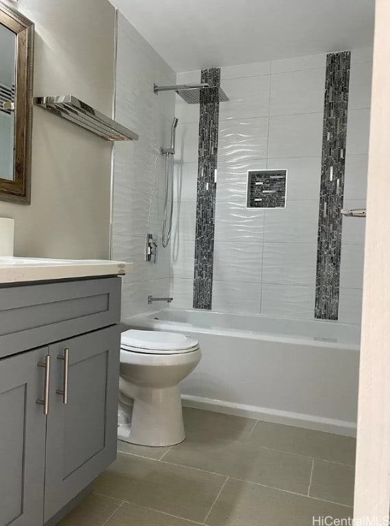 full bathroom with toilet, tiled shower / bath, tile patterned flooring, and vanity