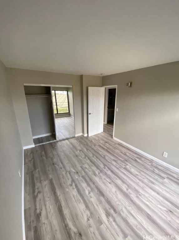 unfurnished bedroom featuring a closet and light hardwood / wood-style flooring