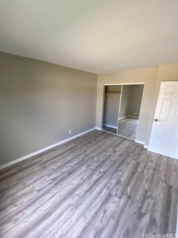 unfurnished bedroom featuring a closet and hardwood / wood-style floors