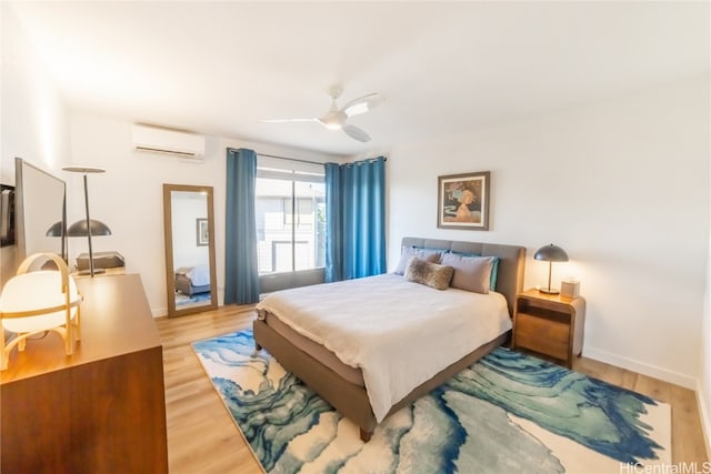 bedroom with a wall mounted air conditioner, hardwood / wood-style flooring, and ceiling fan