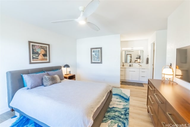 bedroom with connected bathroom, sink, light hardwood / wood-style floors, and ceiling fan