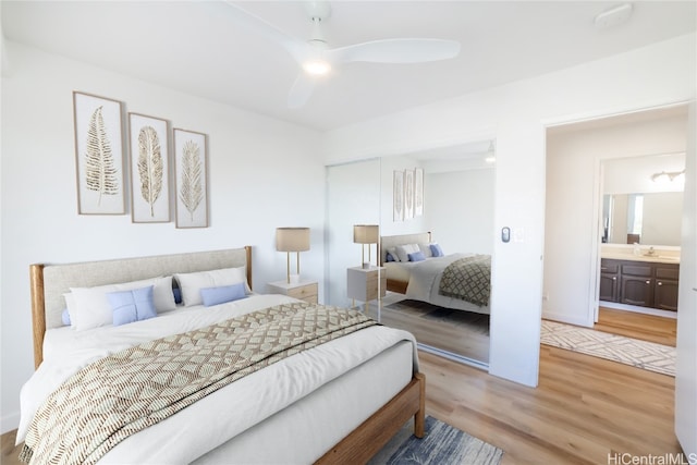 bedroom featuring light hardwood / wood-style flooring, sink, connected bathroom, and ceiling fan