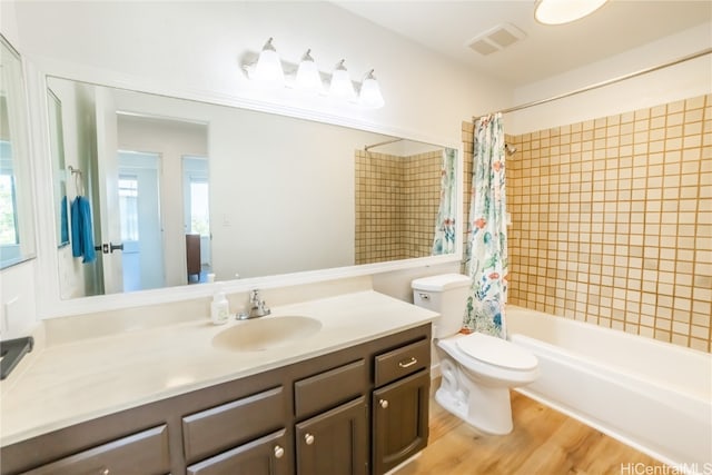 full bathroom with toilet, shower / bath combo, vanity, and plenty of natural light