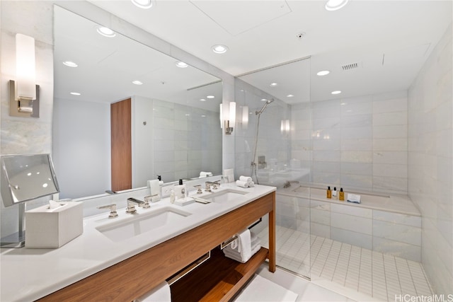 bathroom with tile walls, vanity, and a tile shower