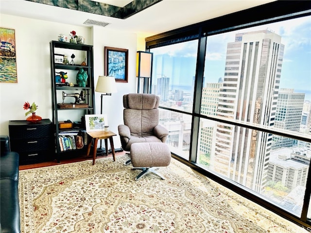 living area with floor to ceiling windows, hardwood / wood-style flooring, and plenty of natural light