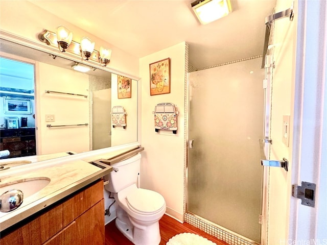 bathroom with vanity, a shower with shower door, wood-type flooring, and toilet