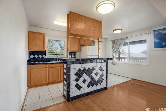 kitchen featuring light hardwood / wood-style flooring, white fridge, and a healthy amount of sunlight