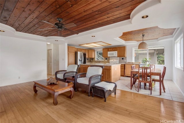 living room with light hardwood / wood-style floors, a raised ceiling, and wood ceiling