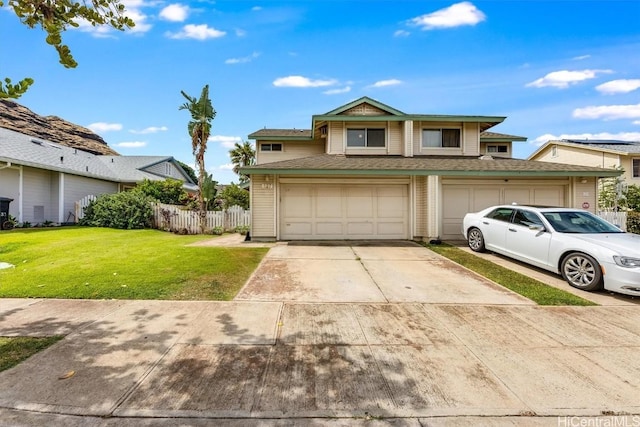 view of property with a front lawn and a garage