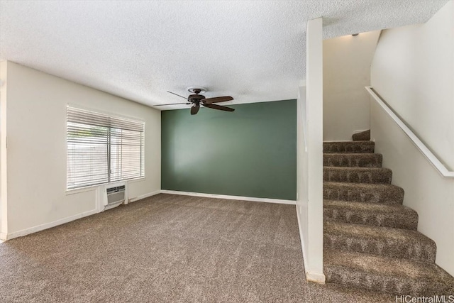 stairway with a textured ceiling, ceiling fan, carpet, and an AC wall unit