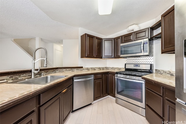 kitchen featuring sink, backsplash, stainless steel appliances, and dark brown cabinets