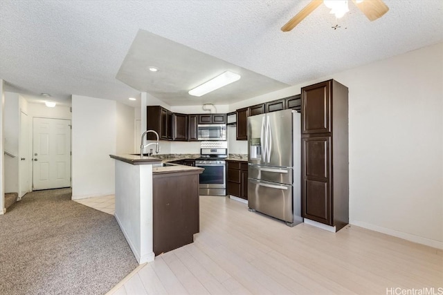 kitchen with ceiling fan, stainless steel appliances, dark brown cabinets, a textured ceiling, and sink