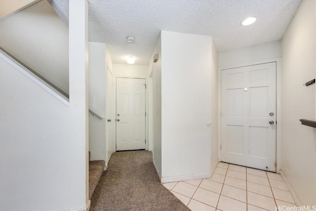 hallway featuring a textured ceiling and light tile patterned floors