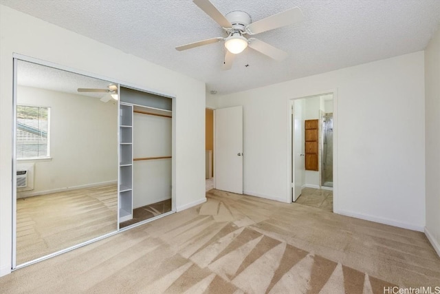 unfurnished bedroom with ceiling fan, a textured ceiling, a closet, and light carpet