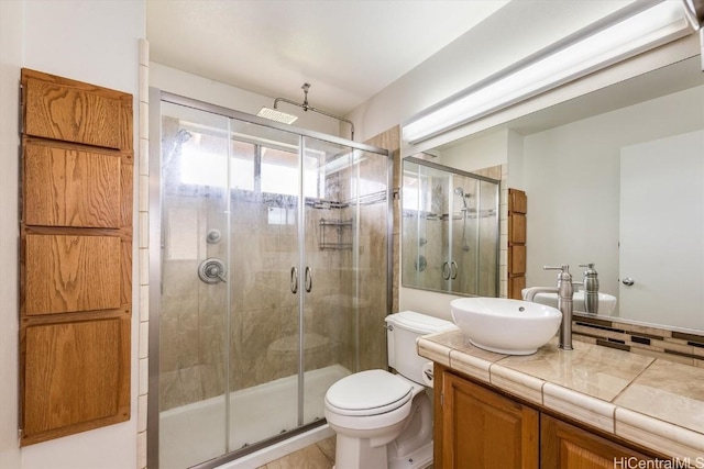 bathroom with decorative backsplash, toilet, a shower with door, and vanity