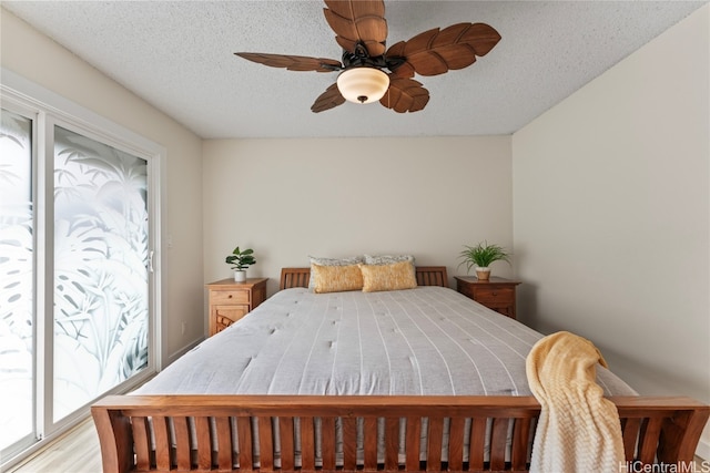 bedroom with a textured ceiling, light hardwood / wood-style floors, and ceiling fan