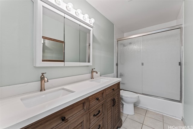 full bathroom featuring vanity, toilet, tile patterned flooring, and bath / shower combo with glass door