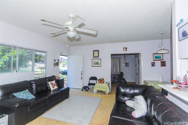 carpeted living room featuring a textured ceiling and ceiling fan