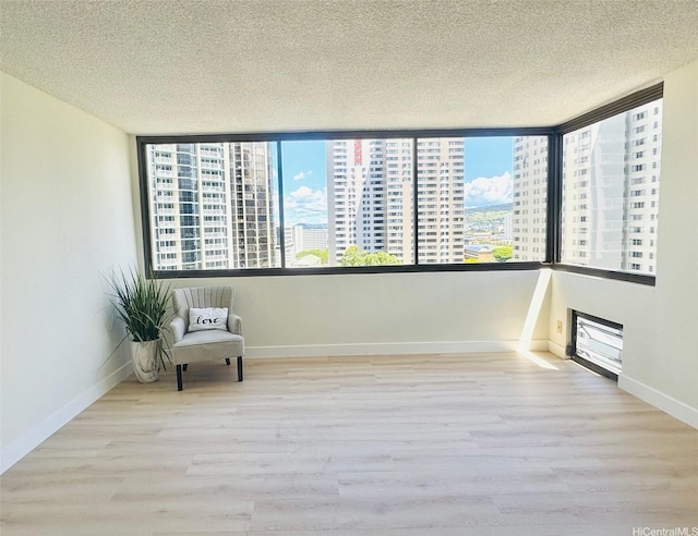 1255 Nuuanu Ave Unit E1414, Honolulu, HI 96817 - unfurnished room with wood finished floors, a textured ceiling, a city view, baseboards, and healthy amount of natural light