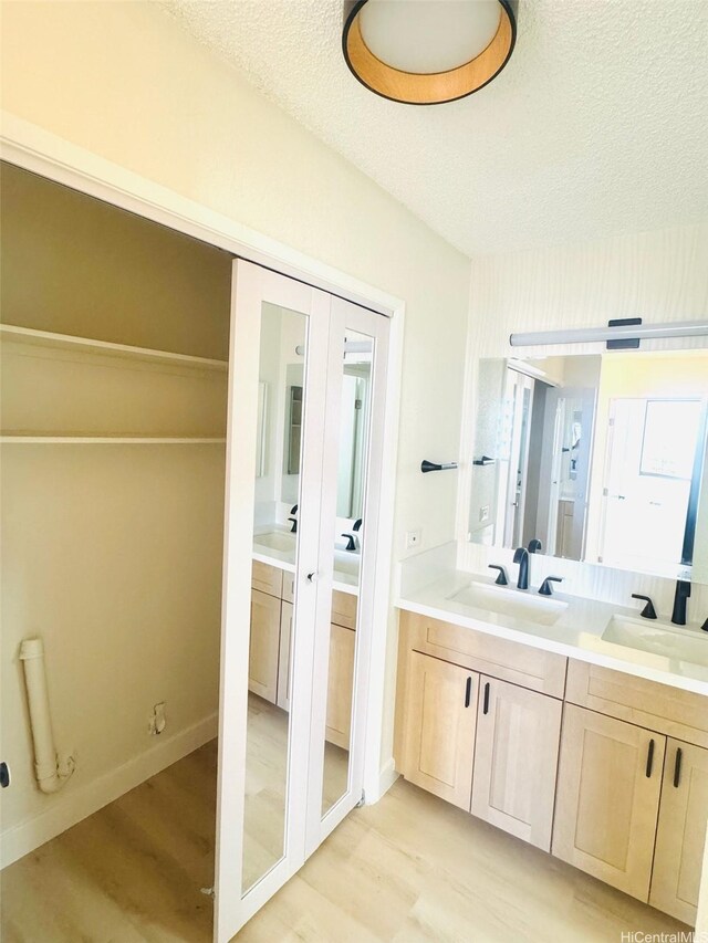 1255 Nuuanu Ave Unit E1414, Honolulu, HI 96817 - bathroom featuring wood finished floors, double vanity, and a textured ceiling