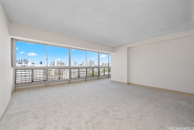 carpeted empty room featuring a textured ceiling